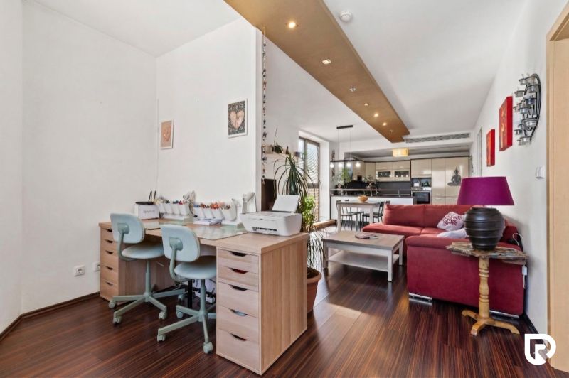 Apartmán vhodný na Airbnb aj rodinné bývanie | Vienna Gate - Interiér 3-izbového bytu s podlahou s dreveným dekorom, pracovným stolom a obývacou zónou.