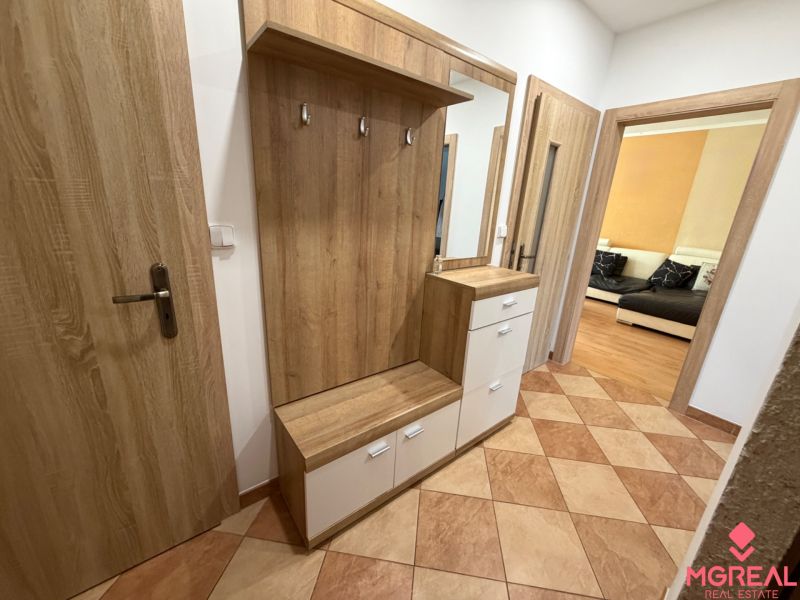 3 izbový byt s balkónom Topoľčany  - Vstupná hala so zrkadlom a skriňou v 3-izbovom byte. Podlaha s dreveným dekorom.