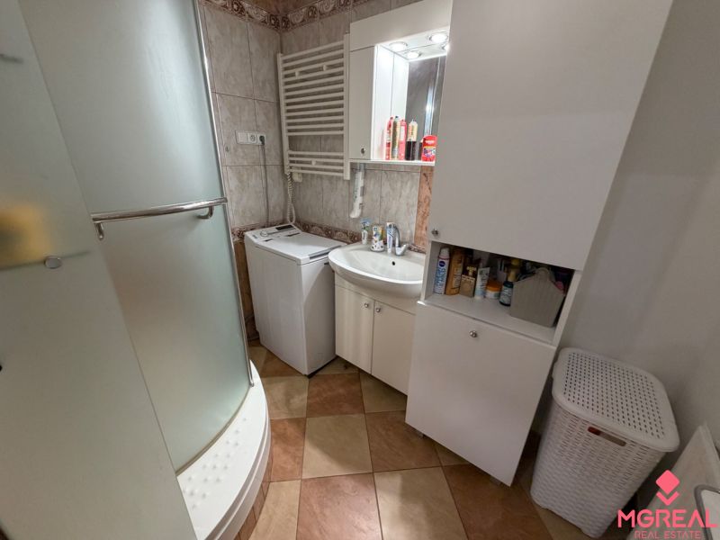 3 izbový byt s balkónom Topoľčany  - Kúpeľňa v 3-izbovom byte s práčkou, sprchovacím kútom a úložnými skrinkami.