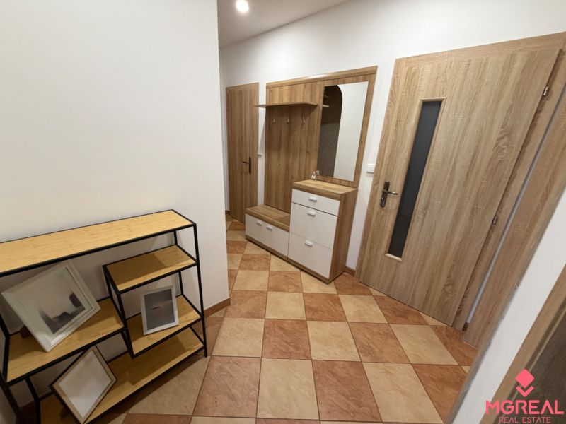 3 izbový byt s balkónom Topoľčany  - Chodba v 3-izbovom byte s dlažbou, vešiakovou stenou a poličkami z dreveným dekorom.