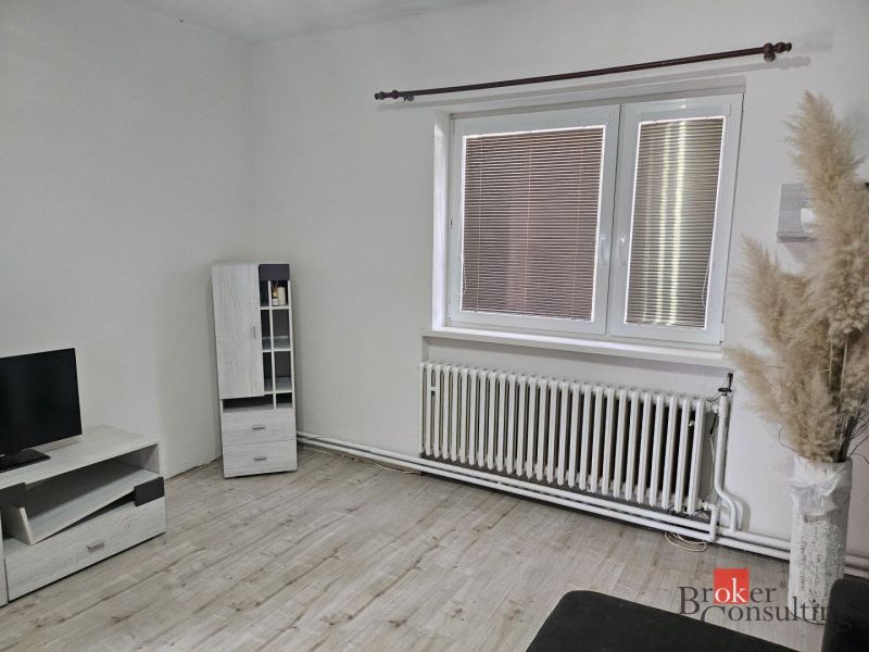 EXKLUZÍVNE NA PREDAJ 2-izbový rodinný dom v širšom centre Nitry s pote - Spálňa so skriňou a oknom, podlaha s dreveným dekorom, posteľ a detská ohrádka.