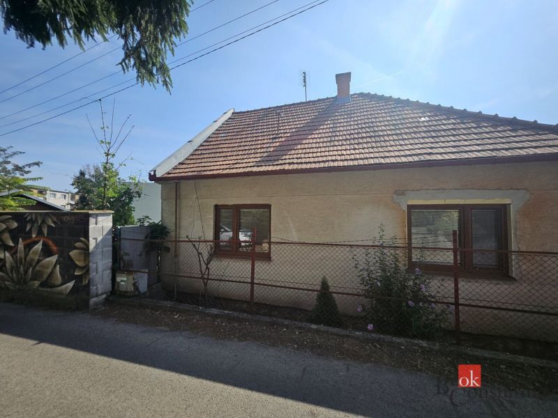 EXKLUZÍVNE NA PREDAJ 2-izbový rodinný dom v širšom centre Nitry s pote - Rodinný dom na Stračej ulici v Nitre s bielou fasádou a šikmou strechou.