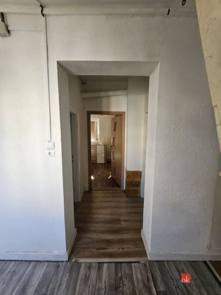 EXKLUZÍVNE NA PREDAJ 2-izbový rodinný dom v širšom centre Nitry s pote - Obývacia izba v rodinnom dome s pohovkou a podlahou s dreveným dekorom.