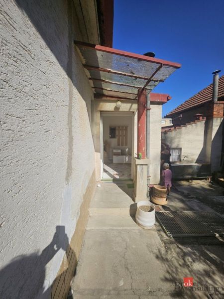 EXKLUZÍVNE NA PREDAJ 2-izbový rodinný dom v širšom centre Nitry s pote - Obývacia izba v rodinnom dome s pohovkou a podlahou s dreveným dekorom.
