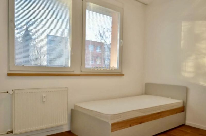 Na prenájom 3-izbový byt po kompletnej rekonštrukcii - ulica Teplická - Spálňa v 3-izbovom byte s veľkými oknami a podlahou s dreveným dekorom.