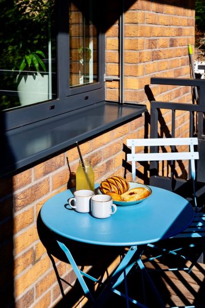 Na prenájom 2-izbový byt v rezidencii STEIN – Bernolákova ulica - V 2-izbovom byte je modrý stolík so šálkami a pečivom na balkóne.