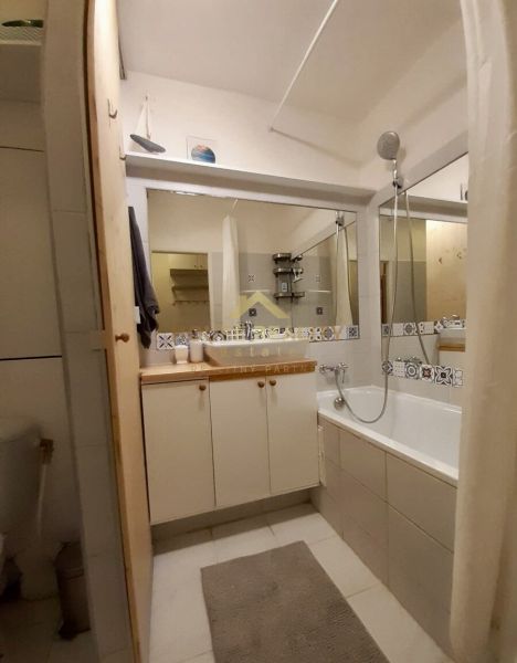 Prenájom 1 izbový byt, ulica Donnerova, Bratislava IV. Karlova Ves - Kúpeľňa v 1-izbovom byte s vaňou a skriňkami so vzorovanými obkladmi.