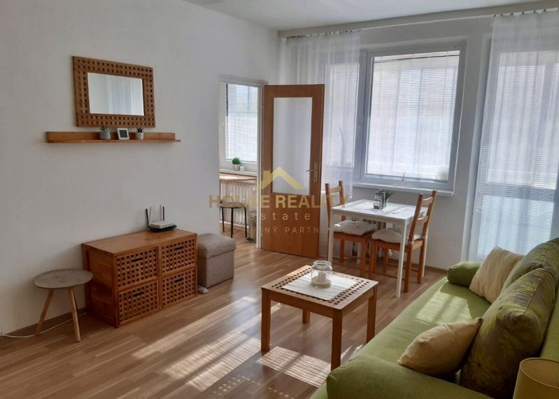 Prenájom 1 izbový byt, ulica Donnerova, Bratislava IV. Karlova Ves - Obývacia časť 1-izbového bytu so svetlým nábytkom a podlahou s dreveným dekorom.