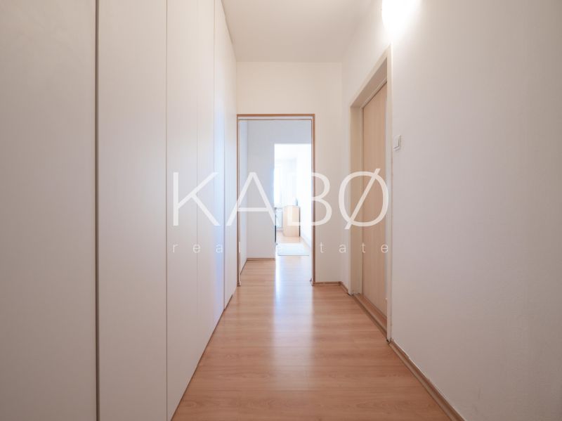 Klimatizácia | Výhľad na Zobor | Balkón a Komfortná veľkosť - Chodba v 2-izbovom byte so skriňami a podlahou s dreveným dekorom.