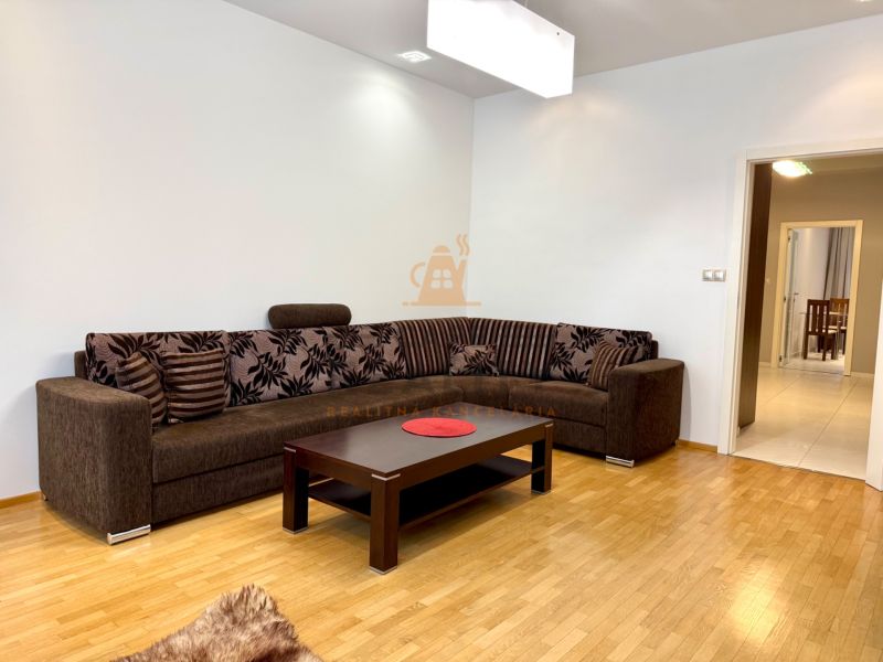 Na prenájom 2 izbový byt, 65 m2, Bratislava, centrum, Vajanského nábr. - Obývačka so sedačkou a stolíkom v 2-izbovom byte s drevenou podlahou.