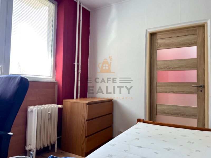 Na predaj 2 izbový byt, 47 m2, Bratislava, Nové Mesto, Piešťanská ul. - Izba v 2-izbovom byte s dreveným dekorom, nábytkom a radiátorom.