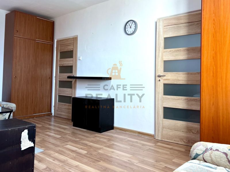 Na predaj 2 izbový byt, 47 m2, Bratislava, Nové Mesto, Piešťanská ul. - Obývacia izba v 2-izbovom byte s podlahou s dreveným dekorom a nábytkom.