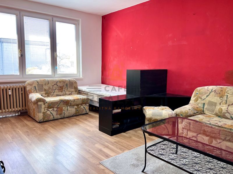 Na predaj 2 izbový byt, 47 m2, Bratislava, Nové Mesto, Piešťanská ul. - Obývacia izba v 2-izbovom byte s kreslami, stolíkom a podlahou s dreveným dekorom.