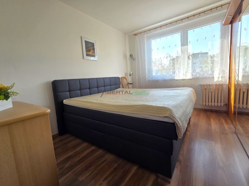 PRENÁJOM 3-izb.byt /loggia/ klíma/ Dudvážska–BA Podunajské Biskupice - Spálňa s veľkou posteľou, podlahou s dreveným dekorom a oknom v 3-izbovom byte.
