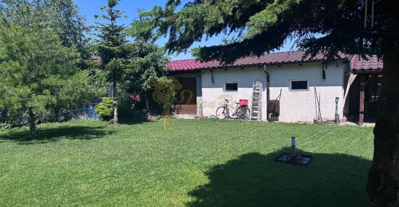 6-izb. rodinný dom, lokalita Nové Košariská, Dunajská Lužná - Záhrada pri rodinnom dome na Nových Košariskách v Dunajskej Lužnej so zeleňou a bicyklom.