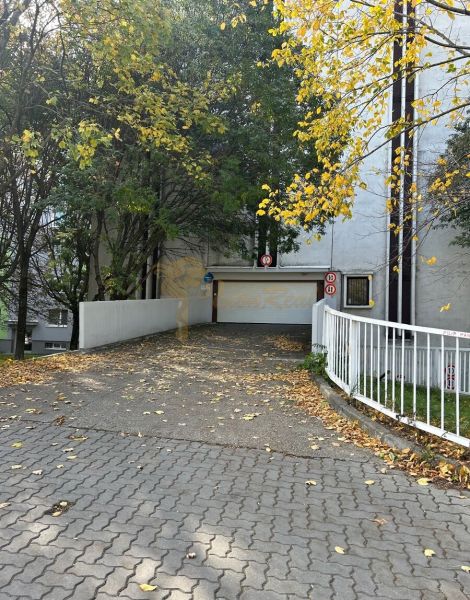 Nadštandardne veľká garáž na ul. Medveďovej, Petržalka - Vchod do garáží na Medveďovej ulici v Bratislave - Petržalke, obklopený jesennými stromami.