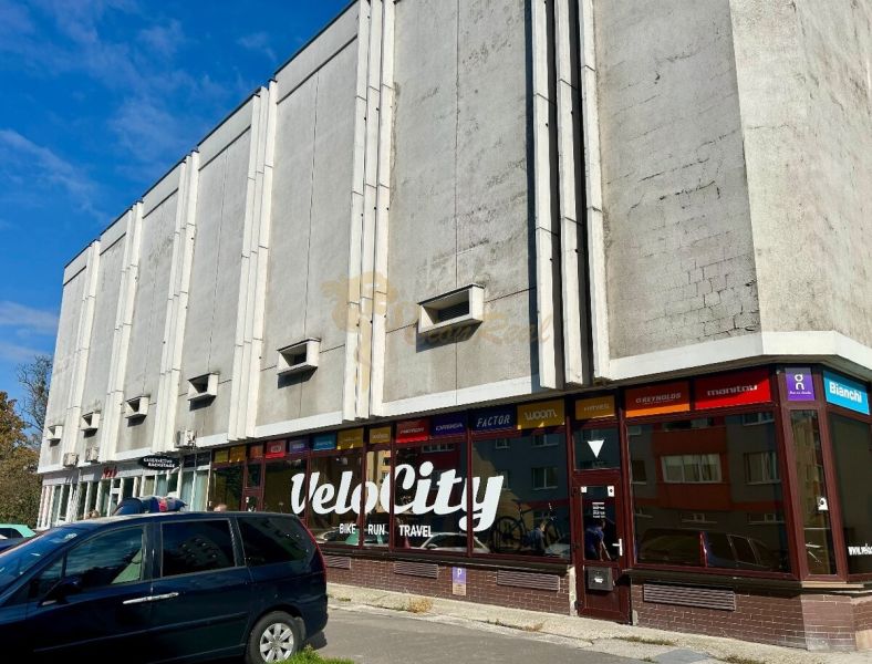 Nadštandardne veľká garáž na ul. Medveďovej, Petržalka - Budova s obchodnými priestormi a parkujúcimi autami na Medveďovej ulici v Petržalke.