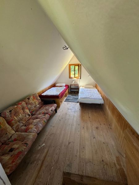 Záhradná chata so záhradou, Devínska cesta, Devín - Podkrovná izba na chate s posteľami a podlahou s dreveným dekorom.