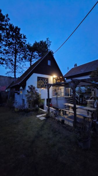 Záhradná chata so záhradou, Devínska cesta, Devín - Chata v Bratislave - Devíne s terasou a záhradou počas súmraku.