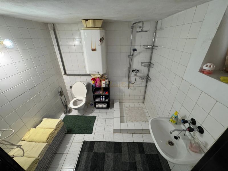 Záhradná chata so záhradou, Devínska cesta, Devín - Kúpeľňa v Chate s bielymi obkladačkami, sprchou, umývadlom a toaletou.
