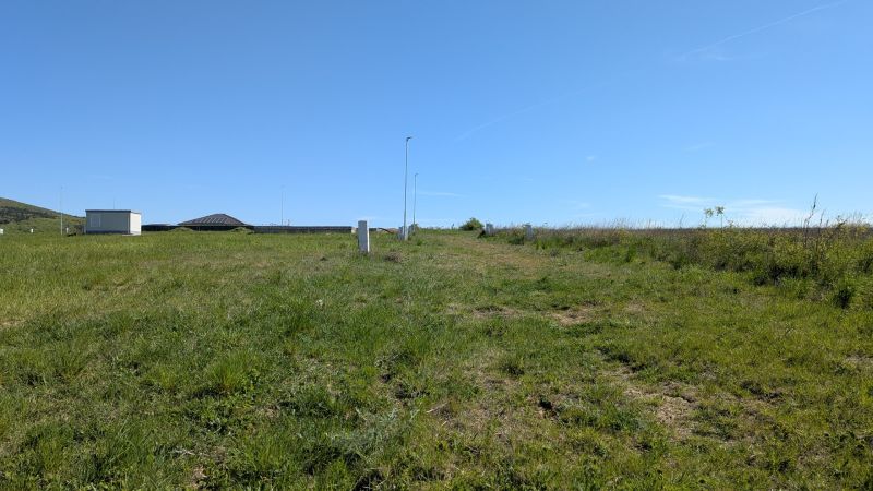Stavebný pozemok v Štitároch 764 m2 s výhľadom na Nitru - Trávnaté pozemky určené pre bývanie v Štitároch pod modrou oblohou.