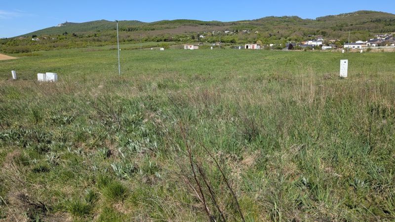 Stavebný pozemok v Štitároch 764 m2 s výhľadom na Nitru - Pozemky - bývanie v Štitároch obklopené zeleňou a horami na horizonte.