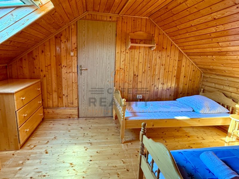 Na predaj chalupa, pozemok 1891 m2, obec Šumiac, okr. Brezno - Podkrovná izba v rodinnom dome s dreveným dekorom a jednoduchým zariadením.