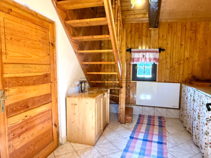 Na predaj chalupa, pozemok 1891 m2, obec Šumiac, okr. Brezno - Interiér rodinného domu s dreveným schodiskom, stropom a dverami, dlažba na podlahe.