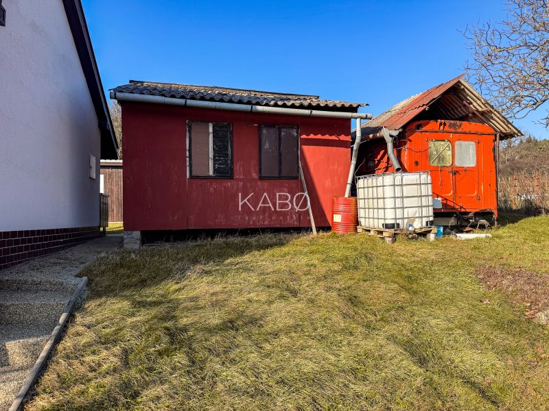 Krásna vinica pri Nitre - 895 m2  - Červené budovy pri viniciach na Ambrovej ulici v Nitre s plastovou nádržou na vodu.