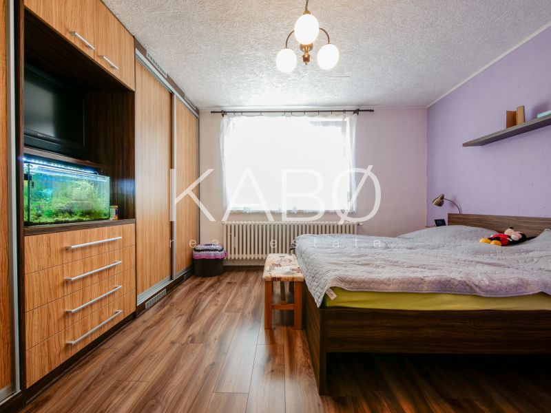 Priestranný 4 izbový rodinný dom po rekonštrukcii - Branč  - Spálňa v rodinnom dome s podlahou s dreveným dekorom, vstavanou skriňou a akváriom.