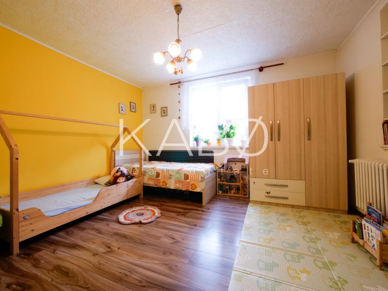 Priestranný 4 izbový rodinný dom po rekonštrukcii - Branč  - Detská izba v rodinnom dome s podlahou s dreveným dekorom a farebnými stenami.
