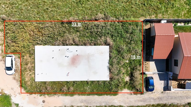Základová doska na  575 m2 pozemku - Čeľadice  - Pozemky - bývanie v Čeľadiciach: zobrazuje oplotený trávnatý pozemok so stavbou.