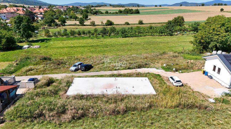 Základová doska na  575 m2 pozemku - Čeľadice  - Pozemky - bývanie v Čeľadiciach, s výhľadom na okolitú krajinu a rodinné domy.