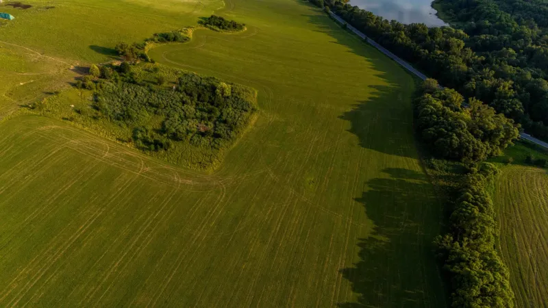 Liptovský Trnovec – 6.488 m2 POZEMOK na MOBILNÝ dom - Letecký pohľad na zelené pláne a lesy v okolí Liptovského Trnovca.