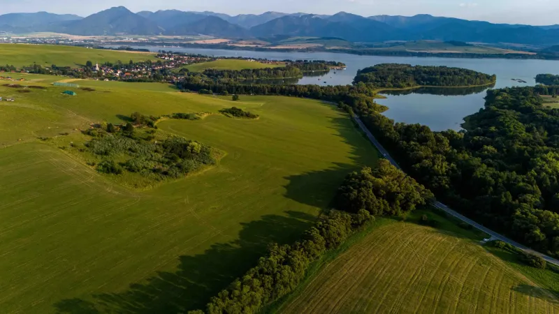 Liptovský Trnovec – 6.488 m2 POZEMOK na MOBILNÝ dom - Liptovský Trnovec ponúka rozsiahlu zeleň s jazerom, obklopenú lesným porastom a poliami.
