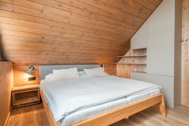 I Luxusné dvojpodlažné chalet pri Liptovskej Mare - Spálňa s drevenými stenami, posteľou a podlahou s dreveným dekorom, Hotely a penzióny.