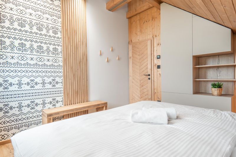 I Luxusné dvojpodlažné chalet pri Liptovskej Mare - Štýlová izba s dekorovanou stenou a podlahou s dreveným dekorom v hoteli.