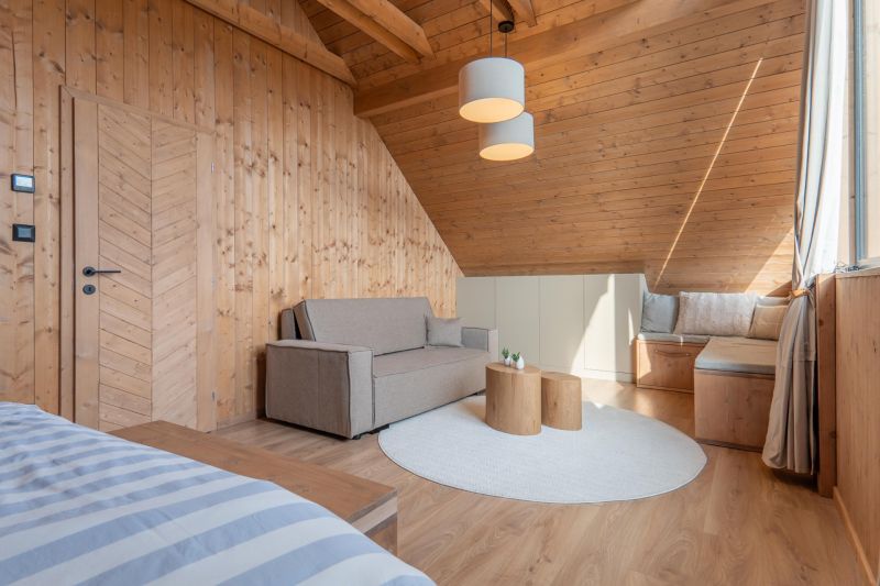 I Luxusné dvojpodlažné chalet pri Liptovskej Mare - Interiér s pohovkou, dreveným obložením a podlahou s dreveným dekorom v Hoteloch a penziónoch.