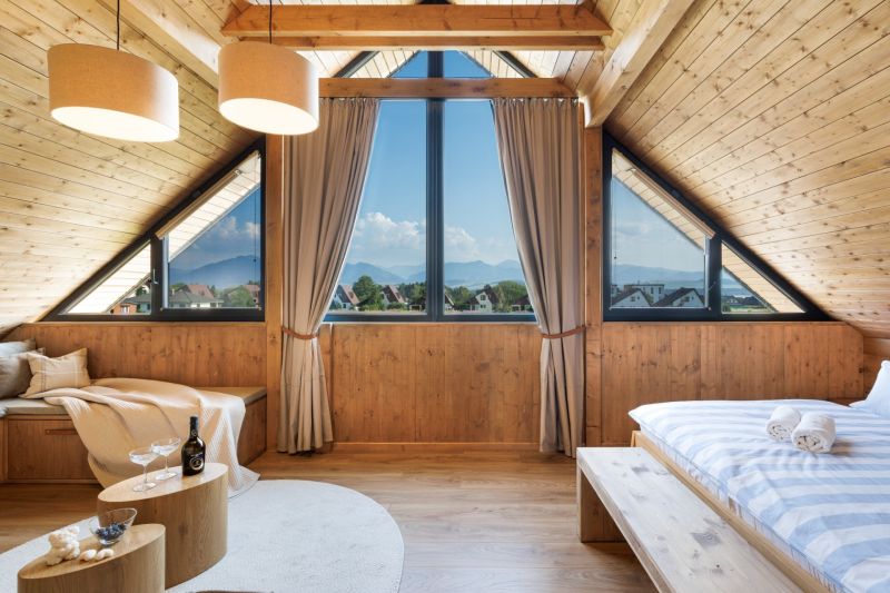 I Luxusné dvojpodlažné chalet pri Liptovskej Mare - Podkrovná izba v chate s panoramatickým výhľadom a podlahou s dreveným dekorom.