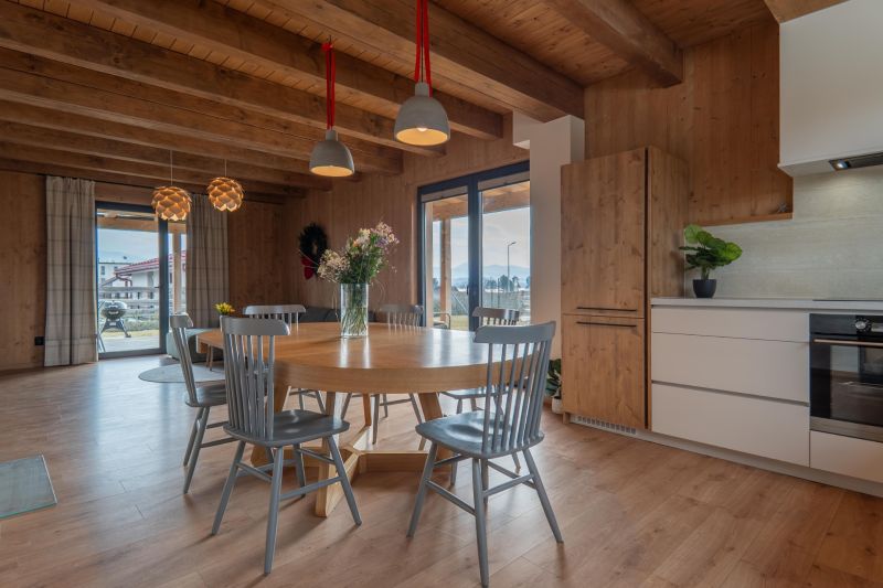 I Luxusné dvojpodlažné chalet pri Liptovskej Mare - Interiér s podlahou s dreveným dekorom, jedálenským stolom a kvetinami v Hotely a penzióny.