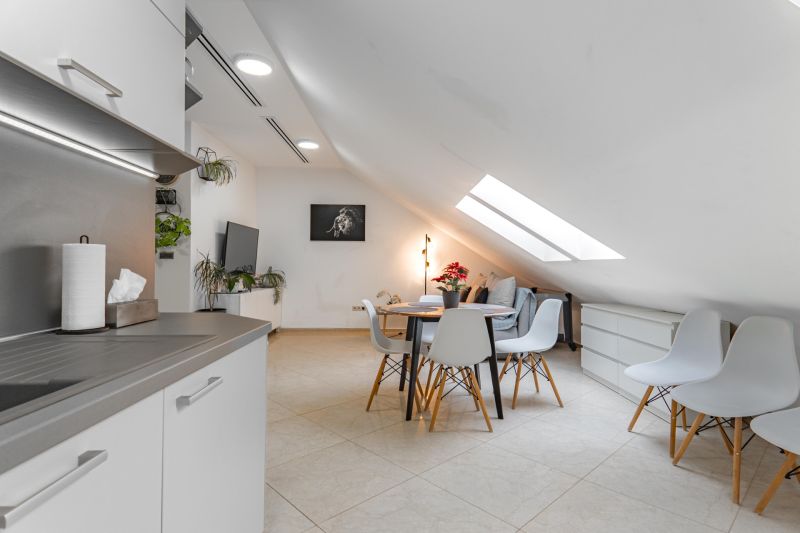 I Exkluzívny penthouse s terasou v absolútnom centre mesta - Otvorený priestor s kuchyňou a jedálenským stolom v 2-izbovom byte, svetlé farby.