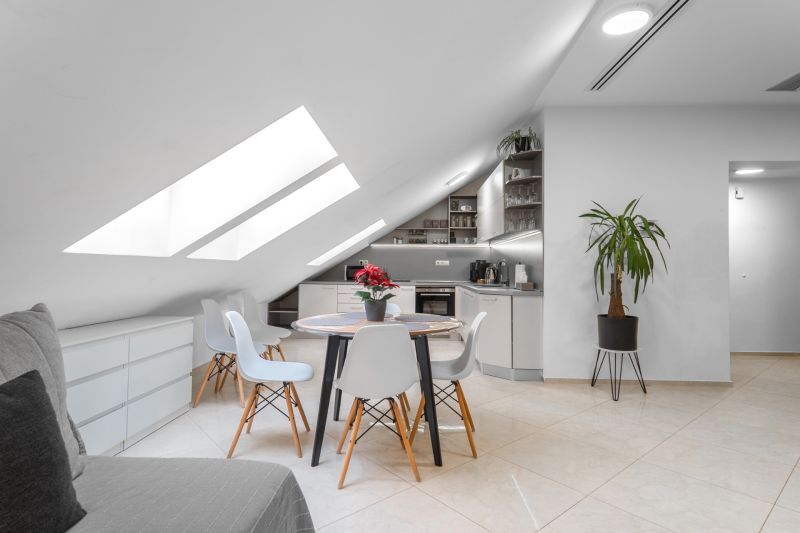 I Exkluzívny penthouse s terasou v absolútnom centre mesta - Podkrovná kuchyňa v 2-izbovom byte s okrúhlym stolom a veľkými strešnými oknami.