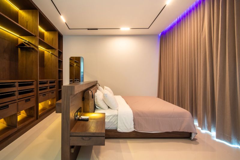 I Na predaj Luxusná vila „Tomma“ v Ubud, Bali - Štýlová spálňa vo Vile s podlahou s dreveným dekorom, veľkou skriňou a útulným osvetlením.