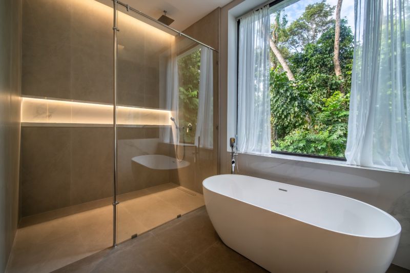 I Na predaj Luxusná vila „Tomma“ v Ubud, Bali - Kúpeľňa vo vile s vaňou, sprchovacím kútom a veľkým oknom s výhľadom na zeleň.