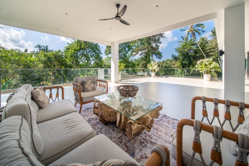 I Na predaj Luxusná vila „Tomma“ v Ubud, Bali - Vila na Bali s terasou, pohovkou, skleneným stolom a výhľadom na džungľu.