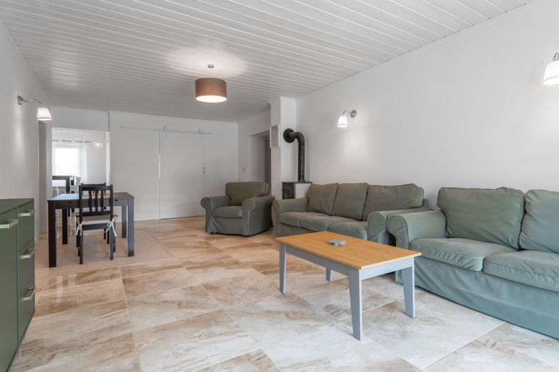 Stavebný pozemok 8 500 m² s podnikateľským potenciálom - Obývacia izba s pohovkami, konferenčným stolíkom a jedálenským kútom na podlahe s dreveným dekorom.