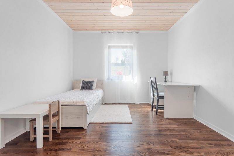 Stavebný pozemok 8 500 m² s podnikateľským potenciálom - Interiér s jedným lôžkom a stolom, podlaha s dreveným dekorom.