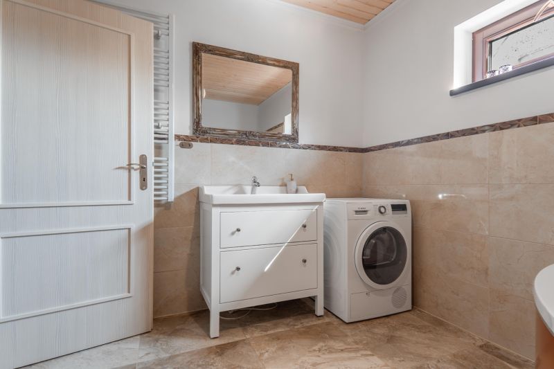 Stavebný pozemok 8 500 m² s podnikateľským potenciálom - Kúpeľňa s práčkou, umývadlom a zrkadlom, podlaha s dreveným dekorom.