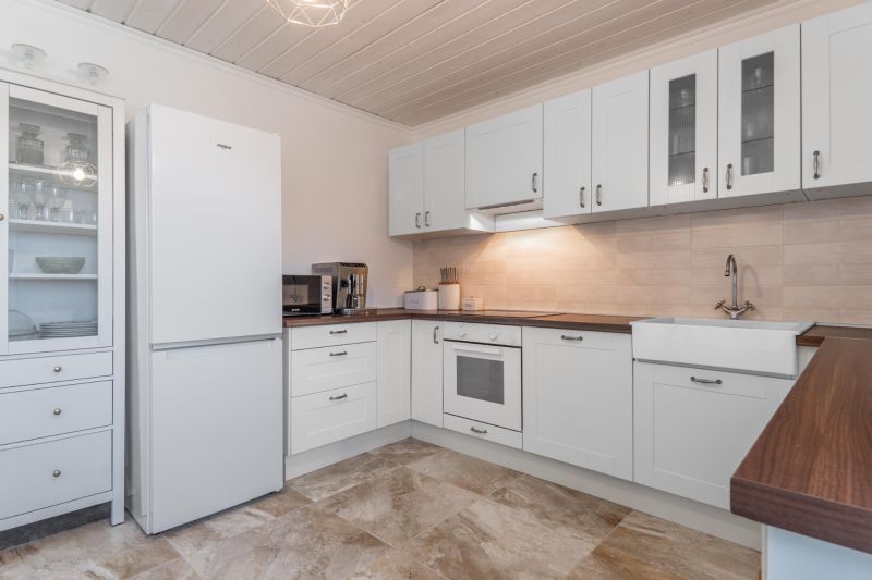 Stavebný pozemok 8 500 m² s podnikateľským potenciálom - Svetlá kuchyňa s bielymi skrinkami a poličkami, podlaha s dreveným dekorom.