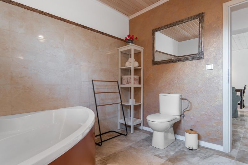 Stavebný pozemok 8 500 m² s podnikateľským potenciálom - Kúpeľňa s vaňou, toaletou, policami a zrkadlom, podlaha s dreveným dekorom.